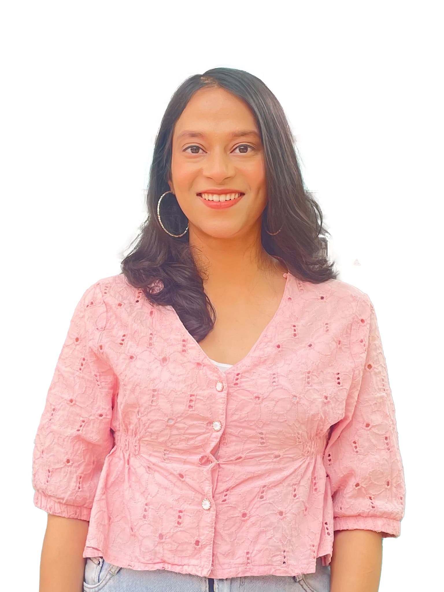 https://media.devpulse.info/A young woman with dark, shoulder-length hair and a warm smile poses for a studio portrait, wearing a light pink, textured top and silver hoop earrings against a plain gray background.